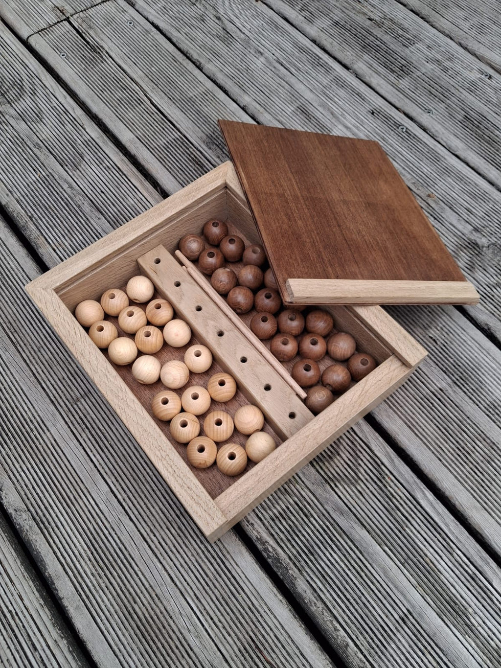 Artisan fabriquant le jeu QuadriBilles en atelier